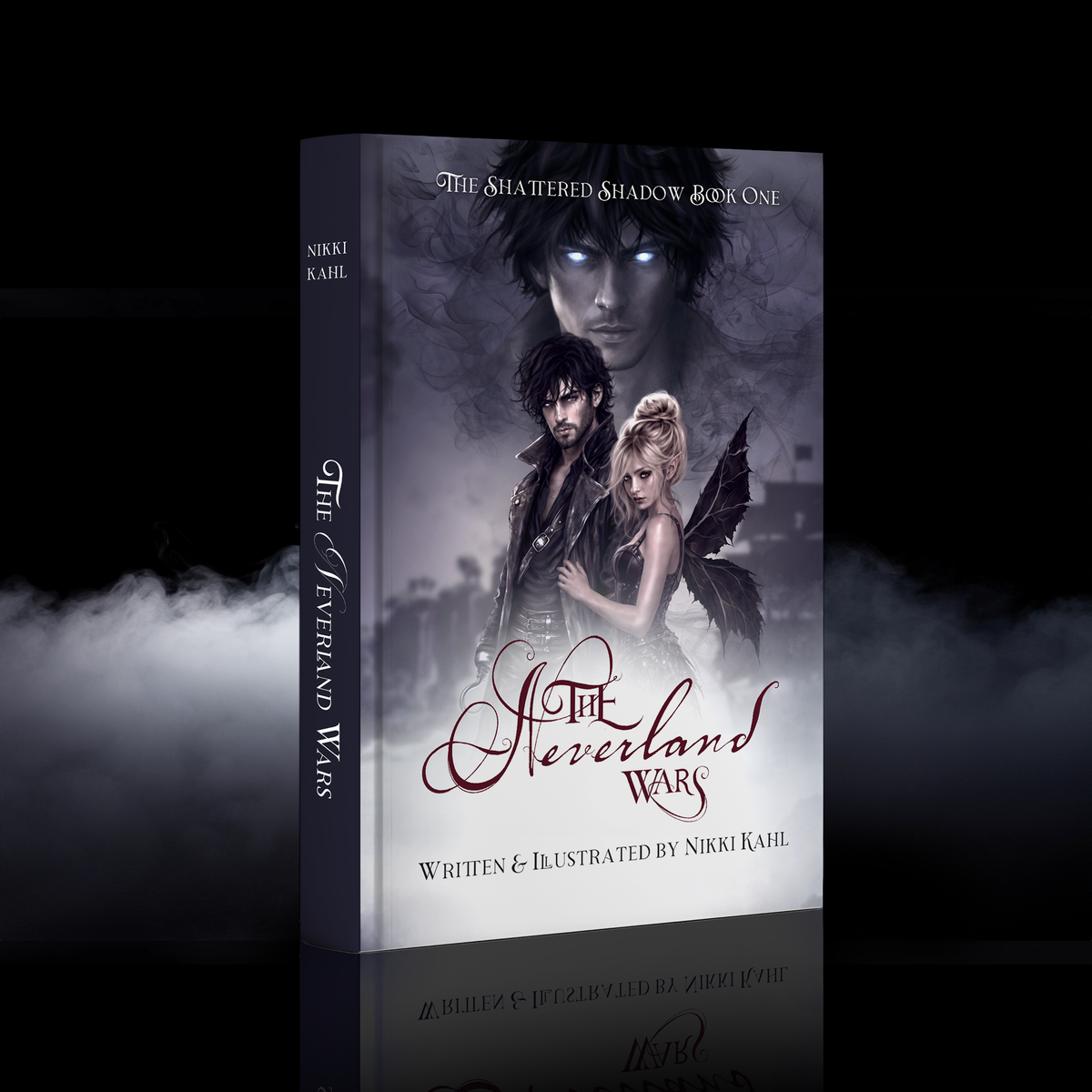 A hardcover book cover for 'The Shattered Shadow Book One: The Neverland Wars' by Nikki Kahl, shown as a 3D product mockup with a dark gothic illustration of two characters and dramatic smoky lighting against a black background.